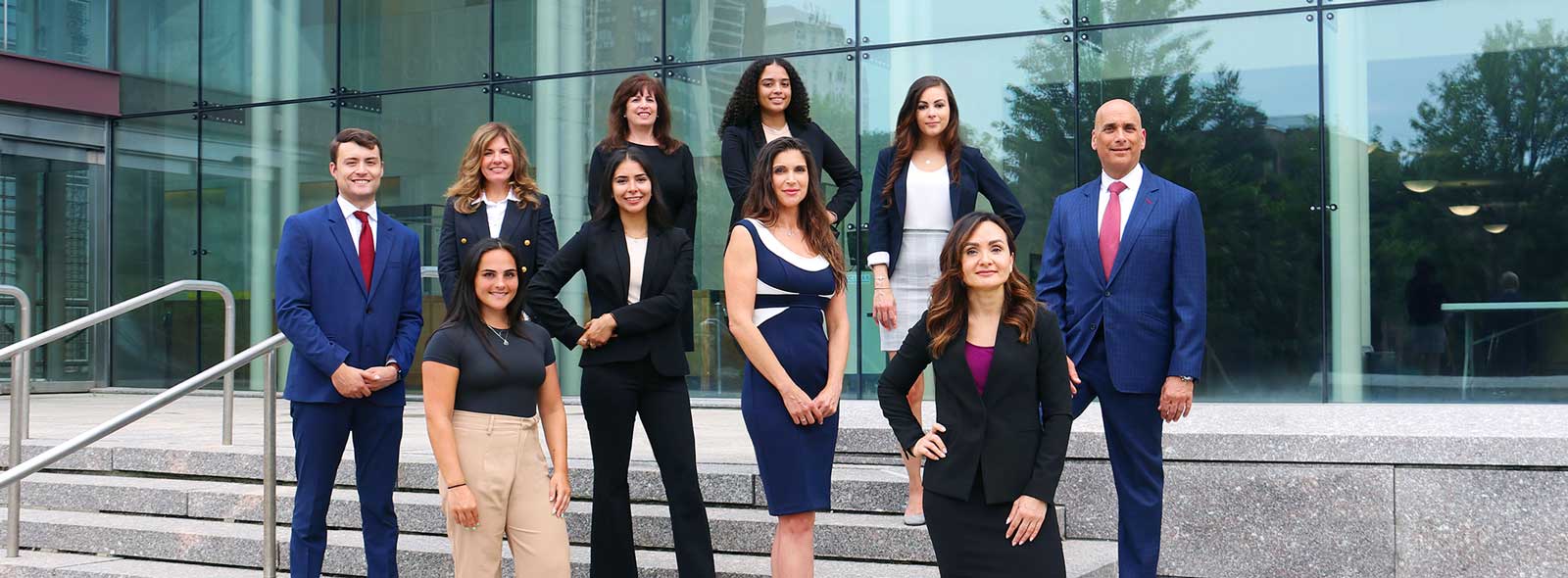 group of professional adults posing in front of office building